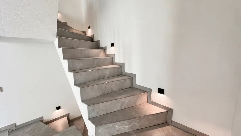 Neu belegte Treppe aus grauem Feinsteinzeug in einem sanierten Haus, ein Projekt von ALL-IN SERVICE